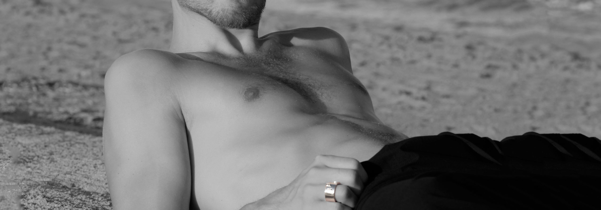 modelo masculino en la playa con anillo de plata